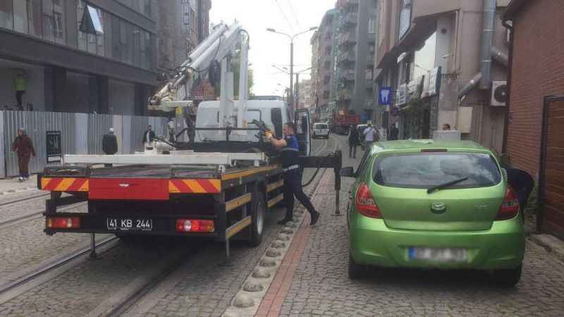 Tramvay yoluna park edilen araçlar çekiliyor  